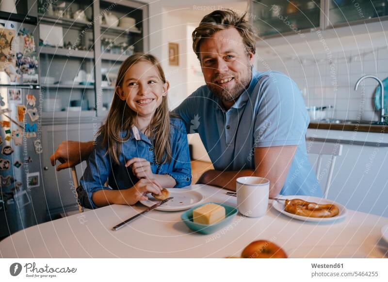 Porträt von Vater und Tochter zu Hause am Frühstückstisch sitzend Blickkontakt Augenkontakt Töchter glücklich Glück glücklich sein glücklichsein genießen