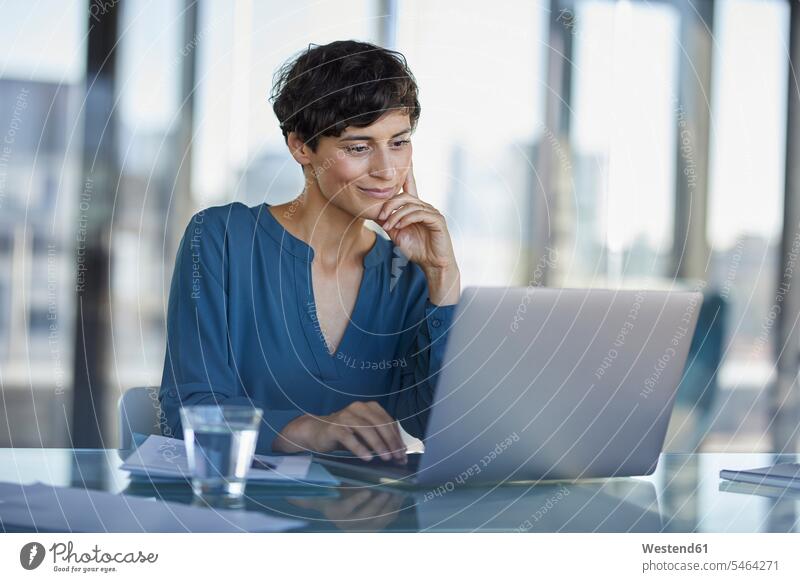 Geschäftsfrau sitzt am Schreibtisch im Büro mit Laptop arbeiten Arbeit Geschäftsfrauen Businesswomen Businessfrauen Businesswoman Office Büros Arbeitstisch