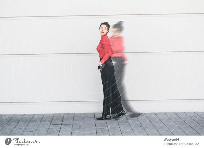 Digitales Kompositum einer jungen Frau, die sich vor einer Wand bewegt Leute Menschen People Person Personen Europäisch Kaukasier kaukasisch 1 Ein ein Mensch