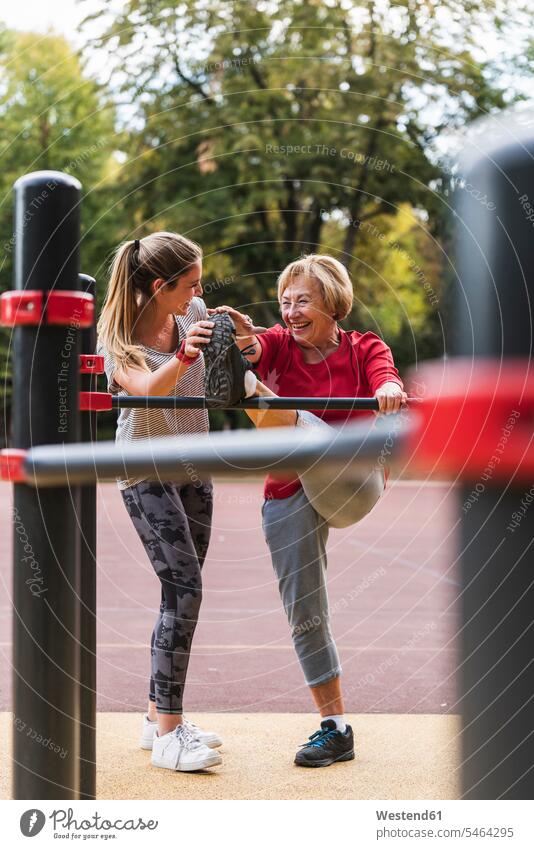 Großmutter und Enkelin trainieren auf Stangen in einem Park Enkeltochter Enkelinnen Enkeltöchter Beweglichkeit Biegsamkeit beweglich Parkanlagen Parks Kraft