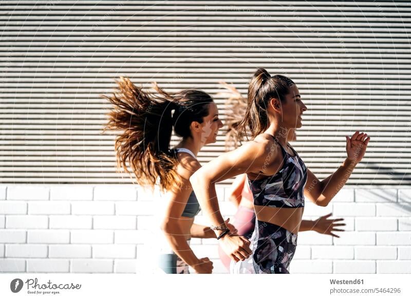 Drei sportliche junge Frauen beim Laufen in der Stadt Leute Menschen People Person Personen Europäisch Kaukasier kaukasisch Gruppe von Menschen Menschengruppe