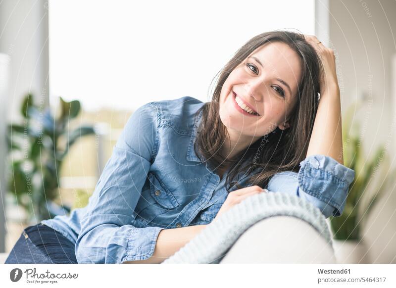 Porträt der glücklichen Frau sitzt auf der Couch zu Hause sitzen sitzend weiblich Frauen Zuhause daheim Glück glücklich sein glücklichsein Portrait Porträts