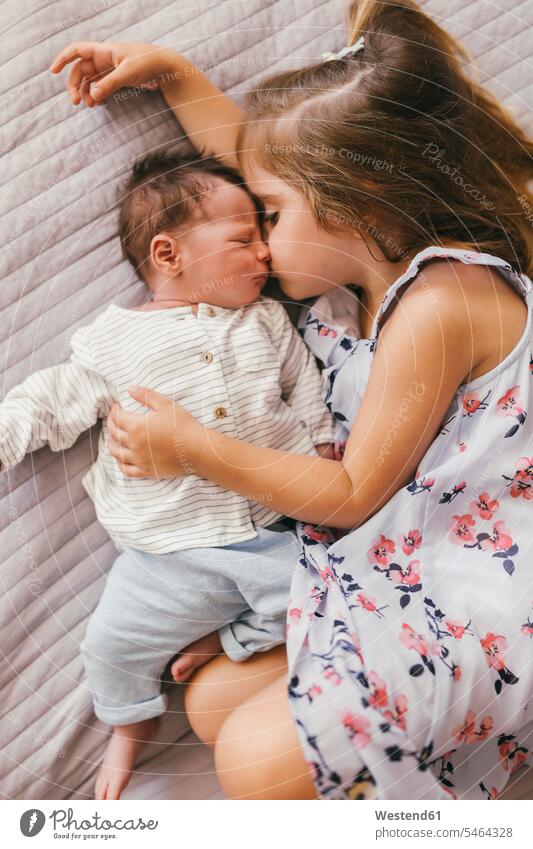 Affectionate Mädchen liegt auf Decke kuscheln mit ihrem kleinen Bruder Decken Baby Babies Babys Säuglinge Kind Kinder liegen liegend Zuneigung weiblich schmusen
