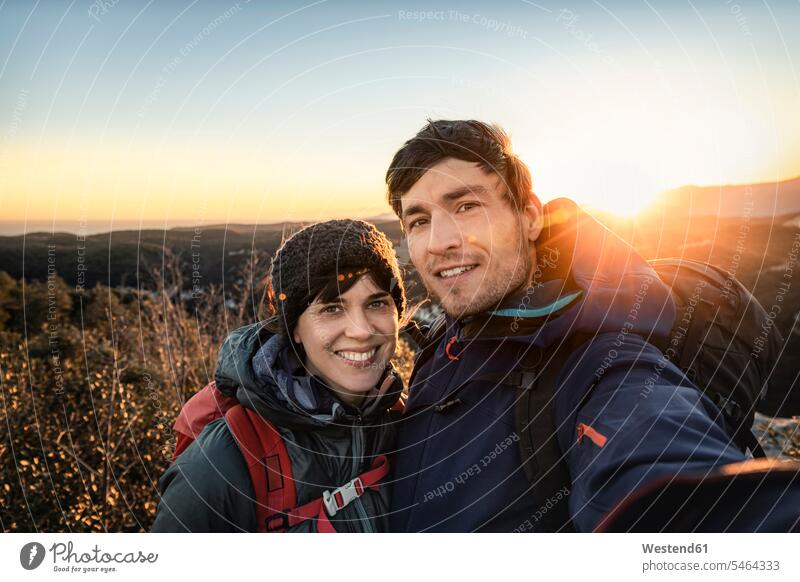 Selfie eines glücklichen Paares an der ligurischen Küste bei Sonnenuntergang, Finale Ligure, Italien Touristen Rucksäcke Jacken entspannen relaxen Wanderung