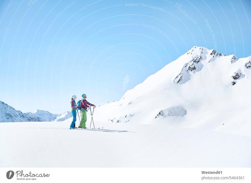 Ein Paar Skitourengeher bei einer Pause in den Bergen, Kühtai, Tirol, Österreich winterlich Winterzeit stehend steht Wintersportart Wintersportarten Muße