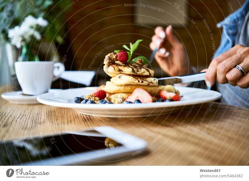 Nahaufnahme einer Frau, die in einem Café Pfannkuchen isst Cafe Kaffeehaus Bistro Cafes Cafés Kaffeehäuser essen essend Pancake Eierkuchen Pancakes weiblich