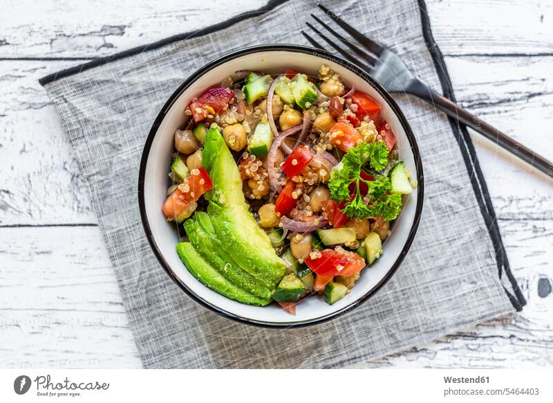 Schüssel mit vegetarischem Quinoa-Salat mit Kichererbsen, Avocado, Gurke, Tomate, Zwiebel und Petersilie Draufsicht von oben Aufsicht Vogelperspektive