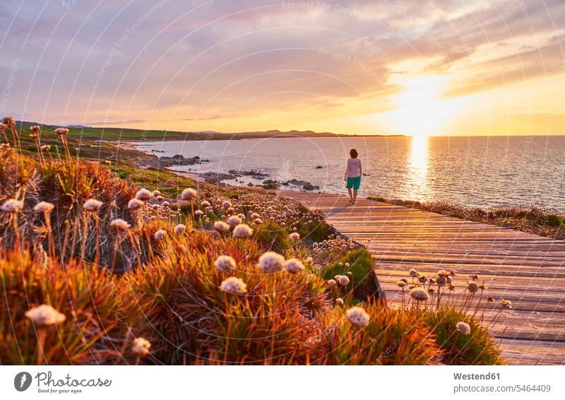 Italien, Sardinien, Lu Litarroni, ältere Frau auf Holzpromenade bei Sonnenuntergang romantisch schwärmerisch schwaermerisch gefuehlvoll gefühlvoll Romantik