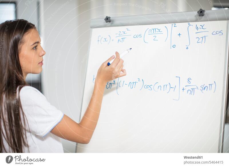 Teenager-Mädchen schreibt Formel auf Whiteboard Klassenzimmer Klassenraum schreiben aufschreiben notieren schreibend Schrift Schule Schulen Weißwandtafel Tafel