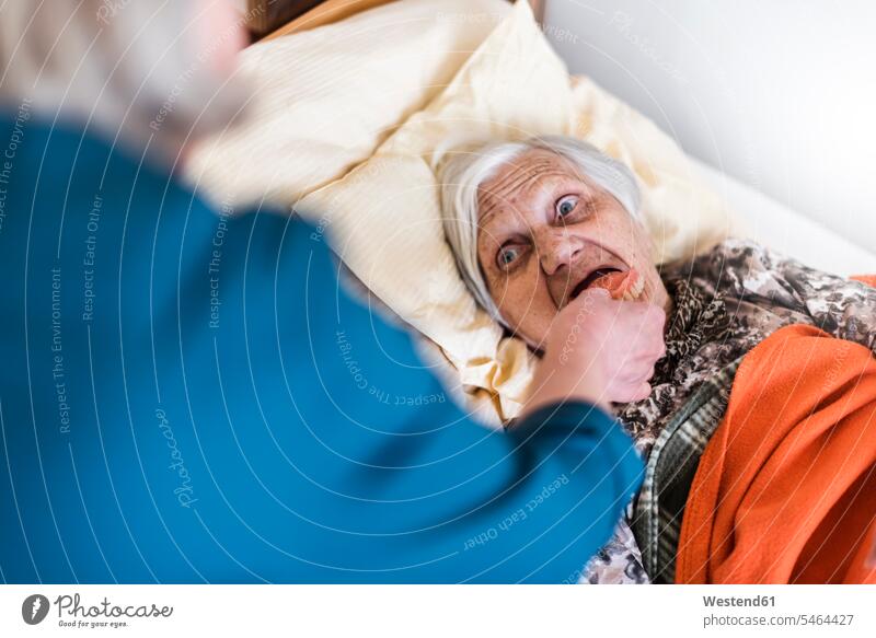Frau kümmert sich um alte, im Bett liegende Frau liegt weiblich Frauen Betten Fürsorge kümmern fürsorglich Pflege Erwachsener erwachsen Mensch Menschen Leute