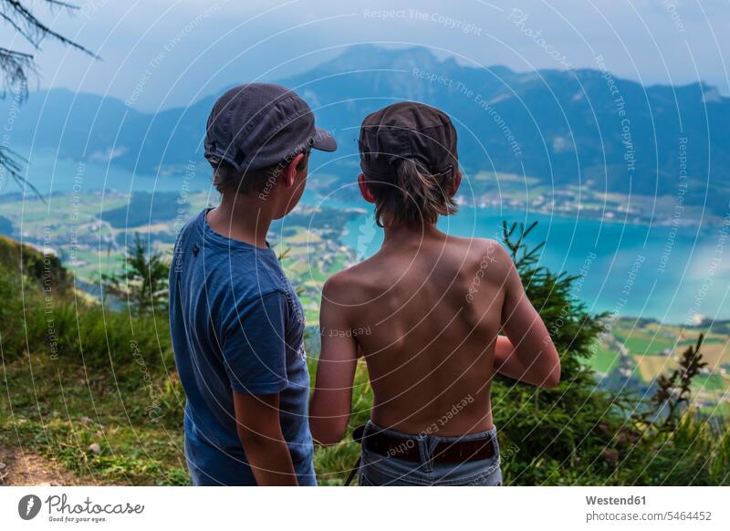 Österreich, Salzkammergut, Mondsee, Rückansicht von zwei Jungen mit Blick auf den See Berglandschaft Berglandschaften Buben Knabe Knaben männlich Gebirge