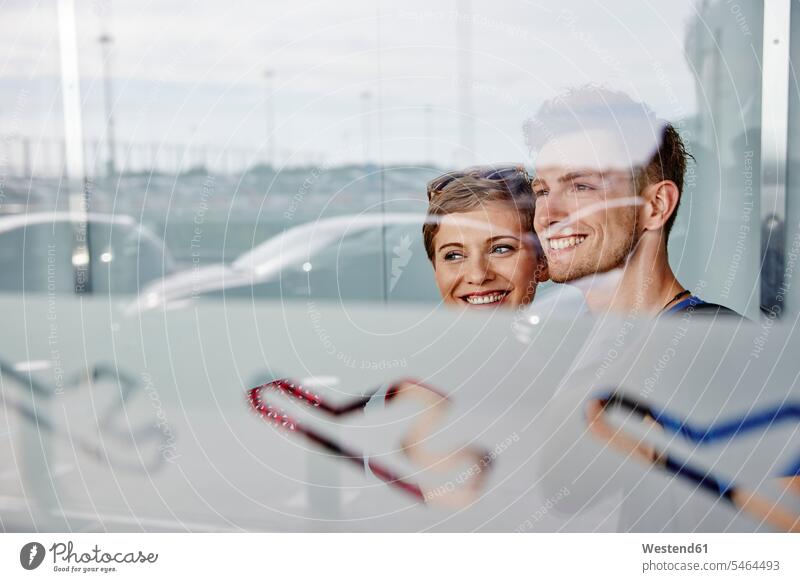 Porträt eines lächelnden Paares am Flughafen mit Blick aus dem Fenster Portrait Porträts Portraits schauen sehend Pärchen Partnerschaft Flughaefen Flugplätze