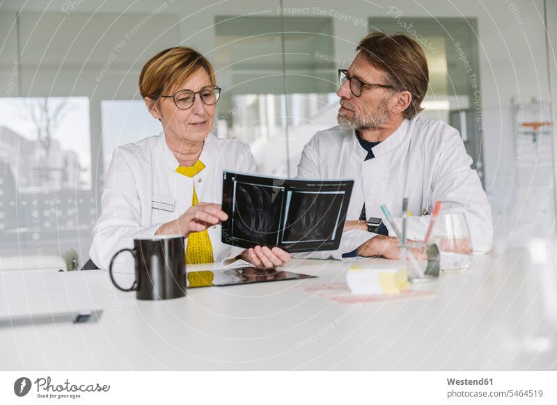 Zwei Ärzte diskutieren über das Röntgenbild einer Hand Job Berufe Berufstätigkeit Beschäftigung Jobs Bilder Bildnis Roentgenbild Roentgenbilder Röntgenbilder