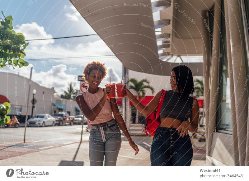 USA, Florida, Miami Beach, zwei glückliche Freundinnen bei einem Softdrink in der Stadt Erfrischungsgetränk Erfrischungsgetraenk Glück glücklich sein