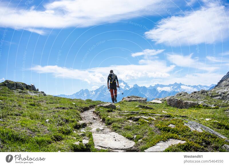 Mann wandert auf Bergpfad in den westlichen rätischen Alpen, Sondrio, Italien Farbaufnahme Farbe Farbfoto Farbphoto Außenaufnahme außen draußen im Freien Tag