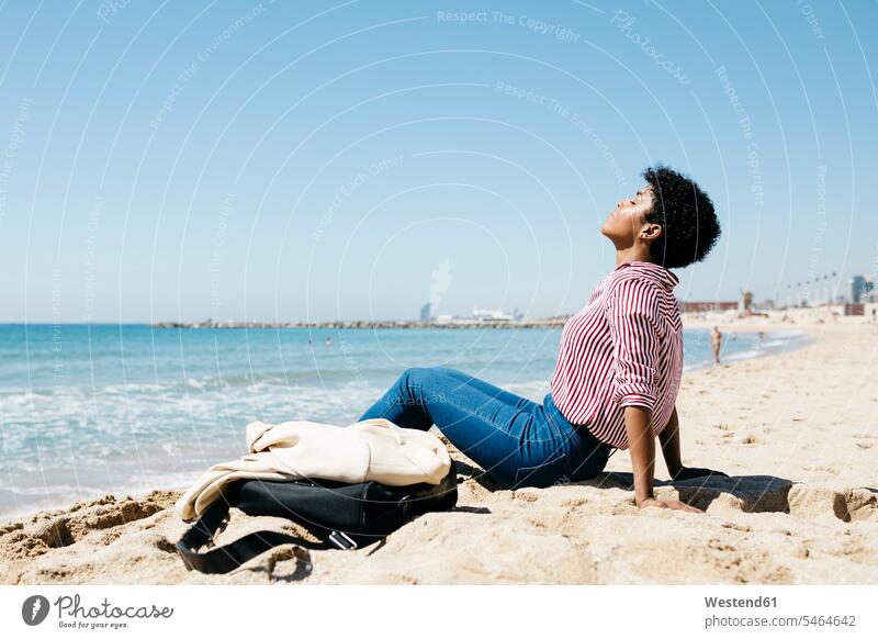 Frau, die nach der Arbeit am Strand sitzt und die Sonne genießt Leute Menschen People Person Personen gemischtrassig 1 Ein ein Mensch eine nur eine Person
