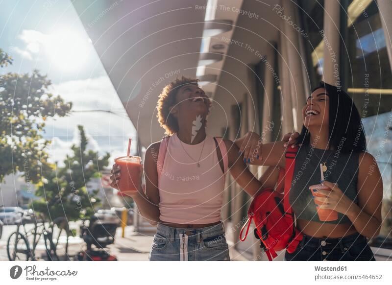 USA, Florida, Miami Beach, zwei glückliche Freundinnen bei einem Softdrink in der Stadt staedtisch städtisch Erfrischungsgetränk Erfrischungsgetraenk Glück