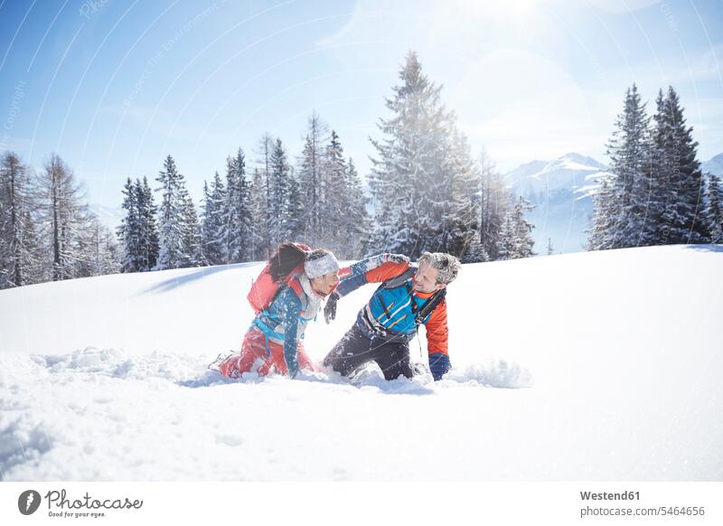 Österreich, Tirol, Paar amüsiert sich im Schnee Schneeballschlacht Schneeballschlachten spielen Winter winterlich Winterzeit lachen Pärchen Paare Partnerschaft