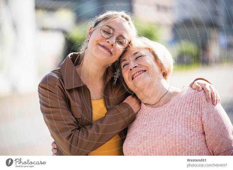 Enkelin umarmt ihre Großmutter Generation Brillen knuddeln schmusen Arm umlegen Umarmung Umarmungen freuen geniessen Genuss Glück glücklich sein glücklichsein