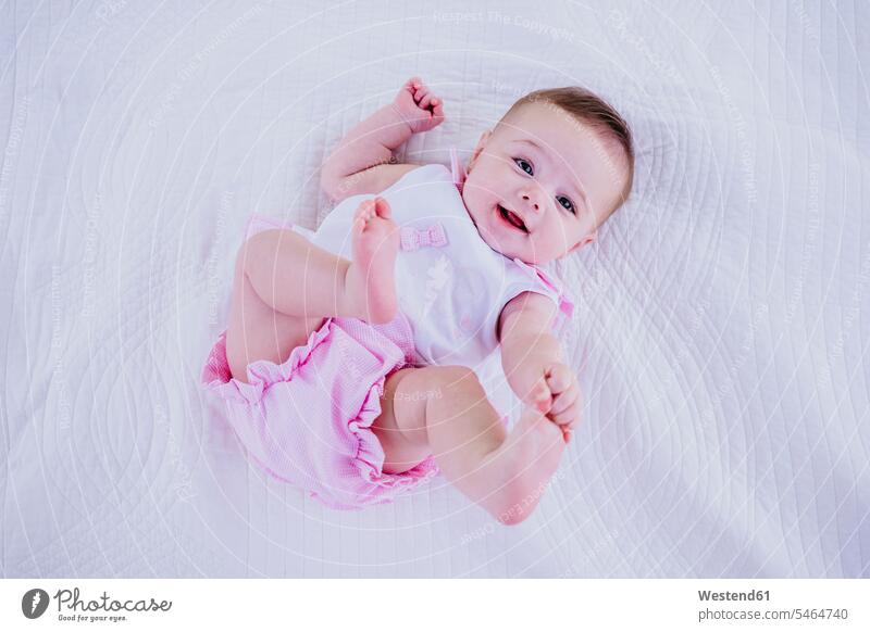Kleines Mädchen berührt Zehen, während es auf einer Decke liegt Farbaufnahme Farbe Farbfoto Farbphoto 2-5 Monate 2 bis 5 Monate 2 - 5 Monate Baby Babys Babies