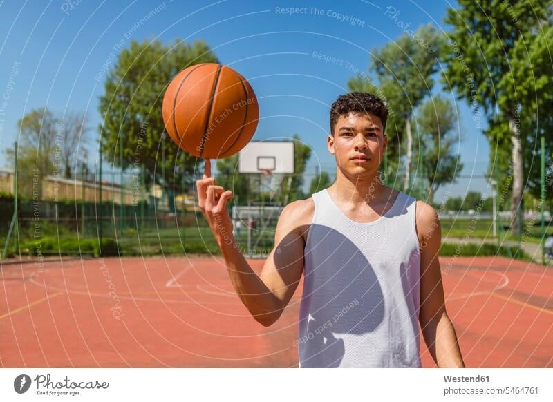 Junger Mann spielt mit Basketball Ball Bälle Spielfeld Sportfelder Spielfelder Können Fähigkeit Fertigkeit Könnerschaft Basketbaelle Basketbälle Basketballfeld