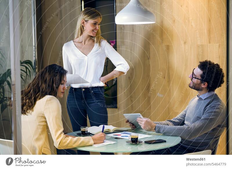 Drei Geschäftsleute bei einer Besprechung in einem modernen Büro Leute Menschen People Person Personen Europäisch Kaukasier kaukasisch Gruppe von Menschen