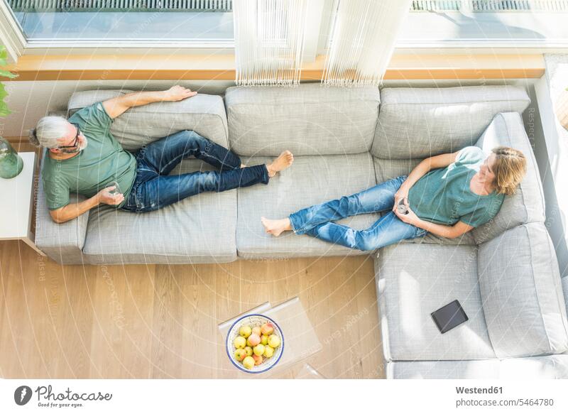 Reifes Paar entspannt sich zu Hause auf der Couch entspanntheit relaxt Zuhause daheim Pärchen Paare Partnerschaft Sofa Couches Liege Sofas Entspannung relaxen