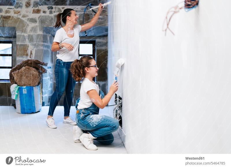 Mutter und Tochter streichen gemeinsam eine Wand ihres neuen Hauses Leute Menschen People Person Personen Europäisch Kaukasier kaukasisch 2 2 Menschen