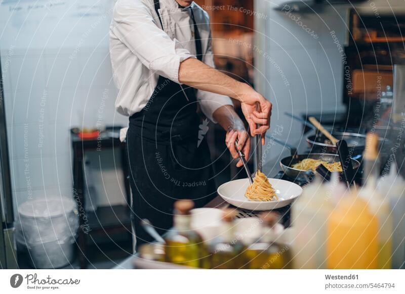 Chefkoch bereitet ein Nudelgericht in der traditionellen italienischen Restaurantküche zu Job Berufe Berufstätigkeit Beschäftigung Jobs Gastronomie Koeche