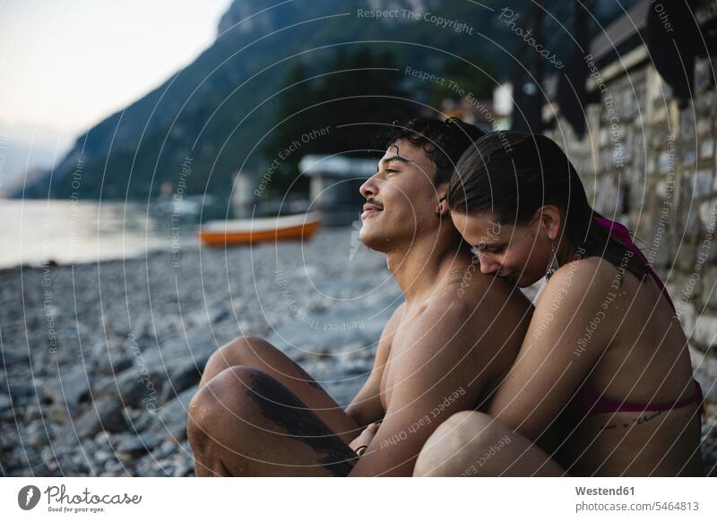 Zärtliches junges Paar entspannt sich nach einem Bad im See entspanntheit relaxt Seen Zuneigung Pärchen Paare Partnerschaft Entspannung relaxen entspannen
