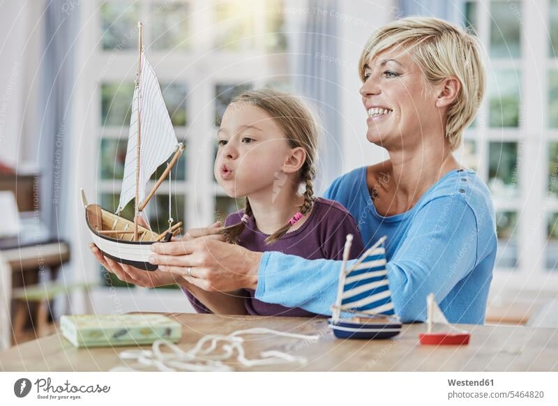 Glückliche Mutter und Tochter spielen zu Hause mit dem Modellboot Mami Mutti Mütter Mama Spielzeugboot glücklich glücklich sein glücklichsein Töchter Zuhause