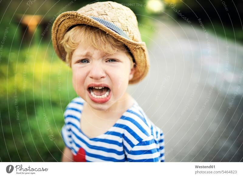 Porträt eines schreienden Kleinkindes mit Strohhut Junge Buben Knabe Jungen Knaben männlich rufen rufend Schrei Strohhüte Strohhuete Portrait Porträts Portraits