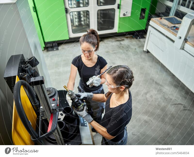 Zwei Frauen arbeiten an einer Maschine Arbeitsplatz Arbeitsstätte Arbeitstelle Starke Frauen Mutige Frau Mutige Frauen Bohrer Maschinen Arbeiterin Arbeiterinnen