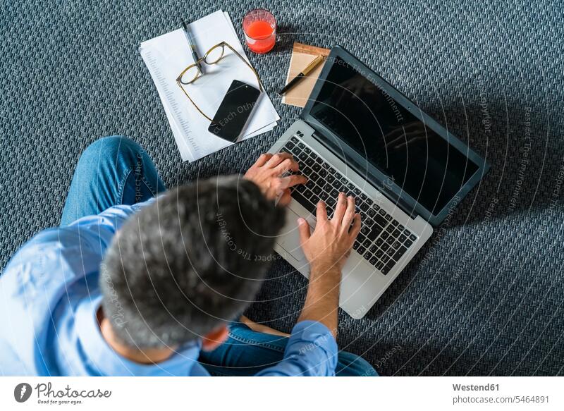 Mann sitzt zu Hause mit Laptop auf dem Boden, Draufsicht Leute Menschen People Person Personen Europäisch Kaukasier kaukasisch 1 Ein ein Mensch eine