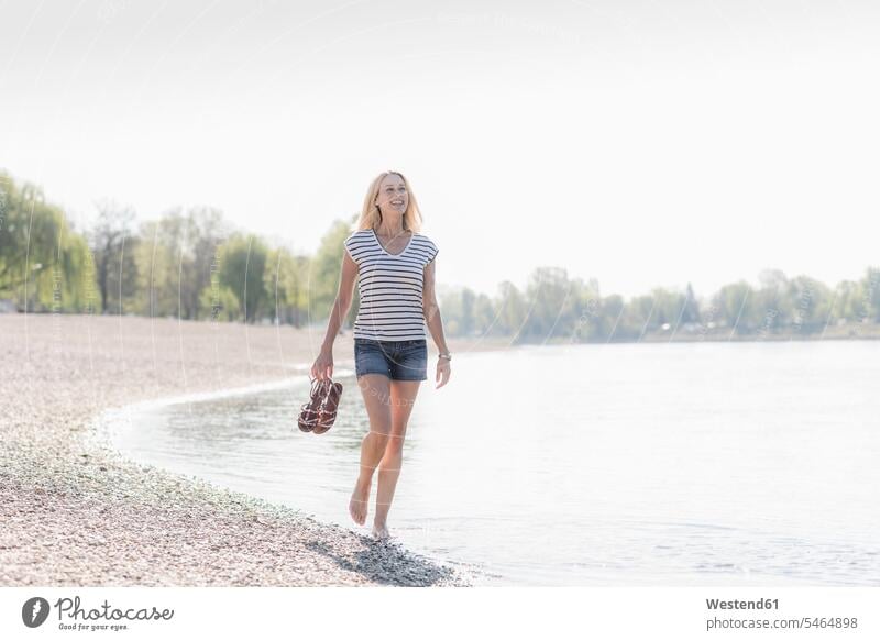 Lächelnde reife Frau watet in einem Fluss Deutschland Top Tops Auszeit Alles hinter sich lassen abschalten entspannen Streifen gestreift geringelt Flussufer