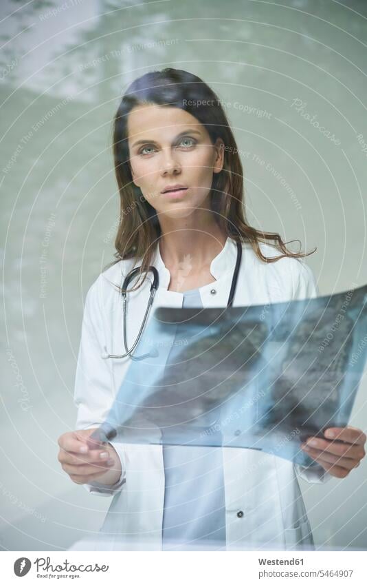 Porträt einer Ärztin mit Röntgenbild hinter Fensterscheibe Job Berufe Berufstätigkeit Beschäftigung Jobs Fensterscheiben Bilder Bildnis Roentgenbild