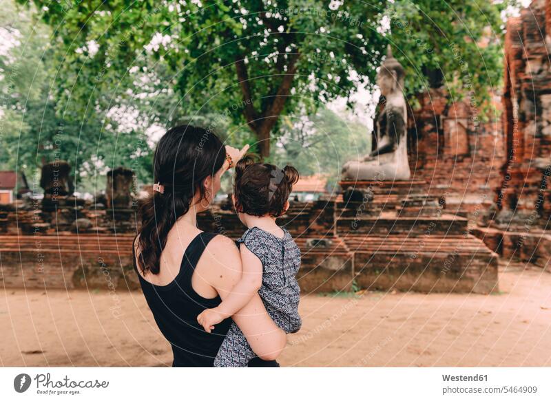 Thailand, Ayutthaya, Mutter und Tochter betrachten eine Buddha-Statue im Wat Mahathat ansehen Buddhas Buddhastatue Buddhafigur Buddhafiguren Buddhastatuen