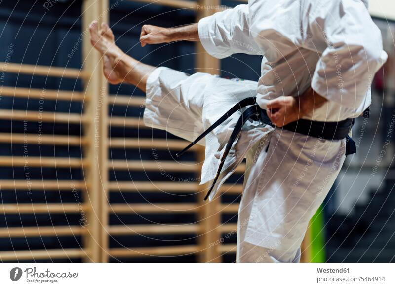 Erwachsener Mann tritt beim Üben von Karate im Unterricht Farbaufnahme Farbe Farbfoto Farbphoto Spanien Innenaufnahme Innenaufnahmen innen drinnen Budo