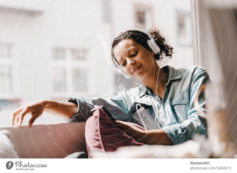 Junge Frau, die im Coworking Space arbeitet und ein Smartphone betrachtet arbeiten Arbeit weiblich Frauen sitzen sitzend sitzt lesen Lektüre Nachricht