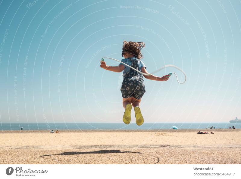 Mädchen spielt mit Springseil, während sie am Strand gegen den klaren Himmel springt Spaß Späße spaßig Freiheit frei Unbeschwert Sorglos Agil Agilität behände