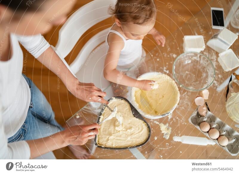 Draufsicht auf Mutter und kleine Tochter machen einen Kuchen zusammen in der Küche zu Hause Küchen Gemeinsam Zusammen Miteinander Mami Mutti Mütter Mama Zuhause