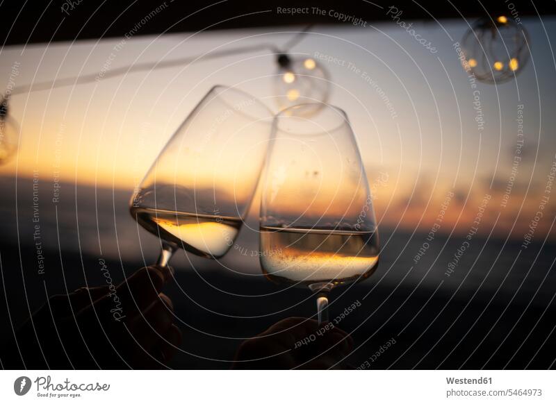 Frau hält bei Sonnenuntergang zwei Gläser Weißwein im Lieferwagen Trinkglas Trinkgläser Weingläser abends gefuehlvoll gefühlvoll Romantik schwaermerisch