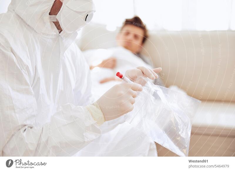 Nahaufnahme eines Arztes, der eine medizinische Probe in einer Plastiktüte hält, während der Patient auf dem Sofa ruht Farbaufnahme Farbe Farbfoto Farbphoto