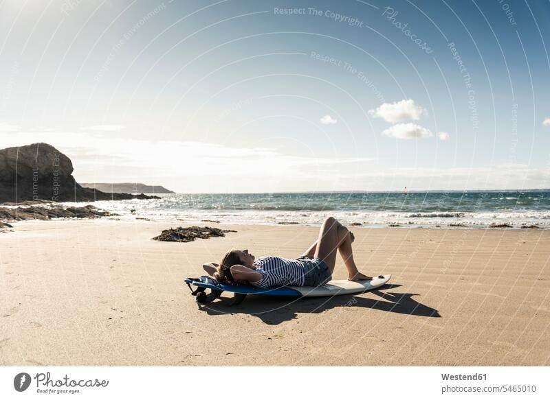 Junge Frau am Strand, entspannt auf Surfbrett Entspannung Entspannen relaxen entspannen junge Frau junge Frauen Beach Straende Strände Beaches Surfbretter
