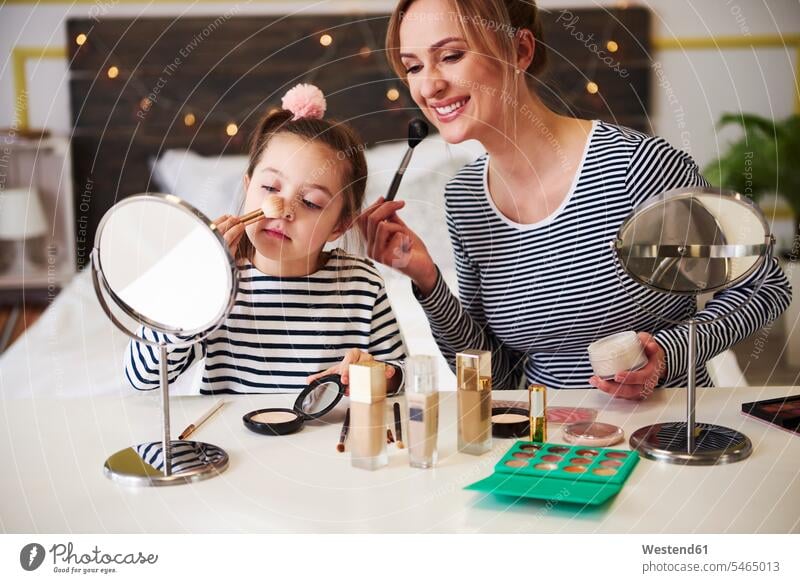 Mutter und Tochter beim gemeinsamen Schminken Spaß Spass Späße spassig Spässe spaßig Make up Make-up sitzen sitzend sitzt Schminktisch Mami Mutti Mütter Mama