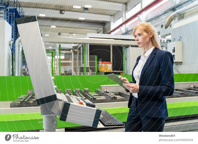 Geschäftsfrau benutzt Tablet an Maschine in Fabrik Tablet Computer Tablet-PC Tablet PC iPad Tablet-Computer Geschäftsfrauen Businesswomen Businessfrauen