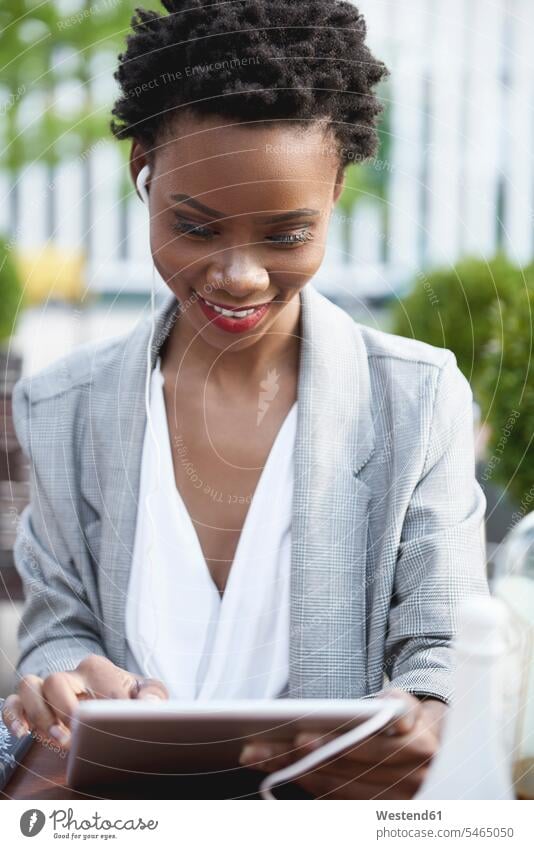 Porträt einer lächelnden Geschäftsfrau, die ein digitales Tablet und Kopfhörer im Freien benutzt benutzen Tablet Computer Tablet-PC Tablet PC iPad