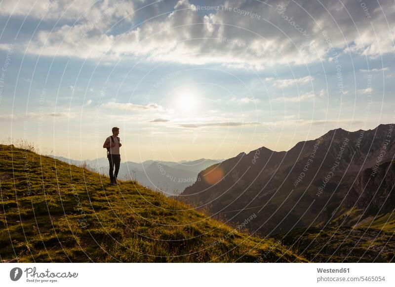 Deutschland, Bayern, Oberstdorf, Mann auf einer Wanderung in den Bergen mit Blick auf den Sonnenuntergang Männer männlich Sonnenuntergänge wandern Aussicht