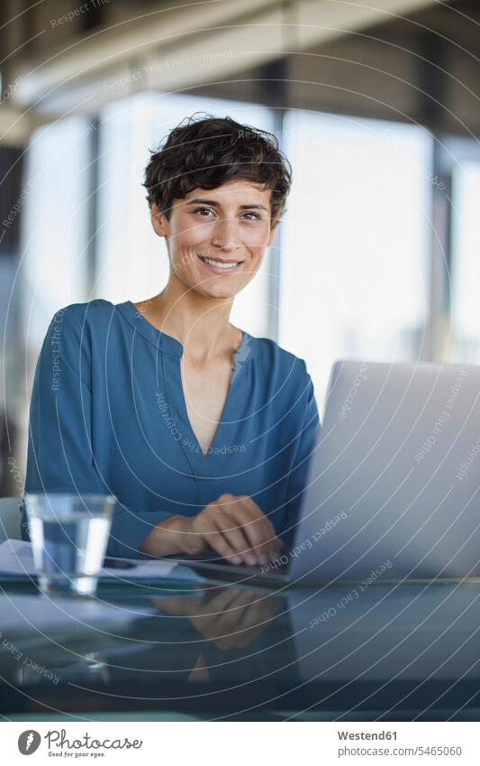 Porträt der zuversichtlich Geschäftsfrau sitzt am Schreibtisch im Büro mit Laptop Geschäftsfrauen Businesswomen Businessfrauen Businesswoman Office Büros