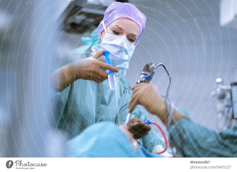 Neurochirurg in Kitteln während einer Operation Krankenhaus Kliniken Krankenhäuser Krankenhaeuser OP Operationen operieren Chirurgie Operationskittel Ärztin
